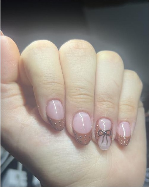 Nude pink nails with delicate bow art and gold dot accents