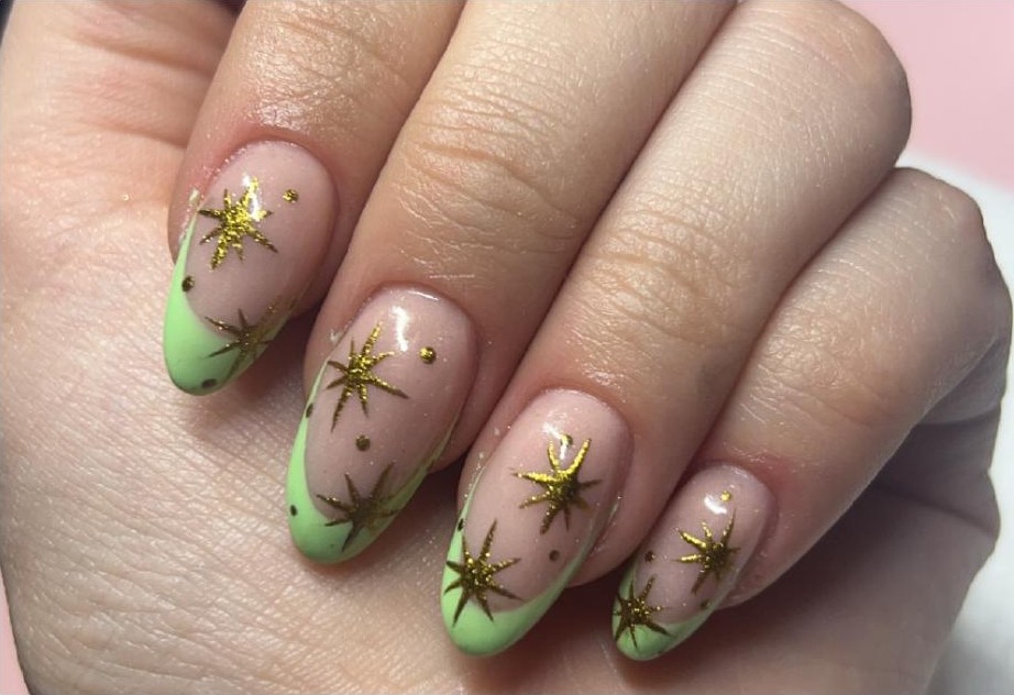 Green French tip nails with gold star detail art by Chaos & Claws